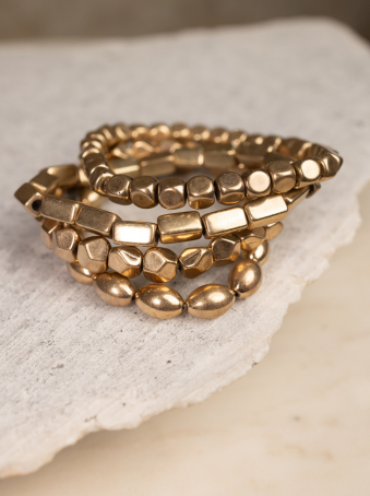 Set de 4 pulseras elásticas doradas con cuentas geométricas